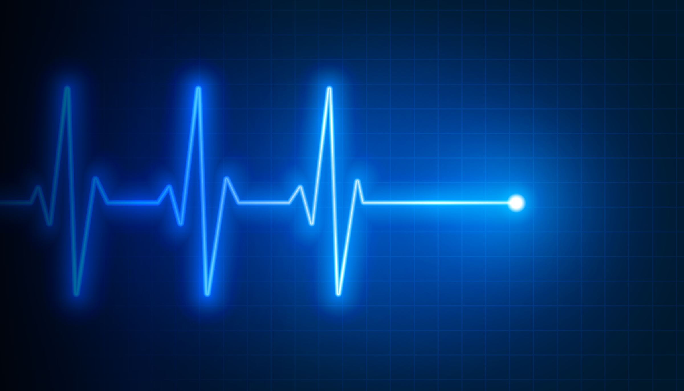 A glowing heartbeat trace on an ECG monitor grid