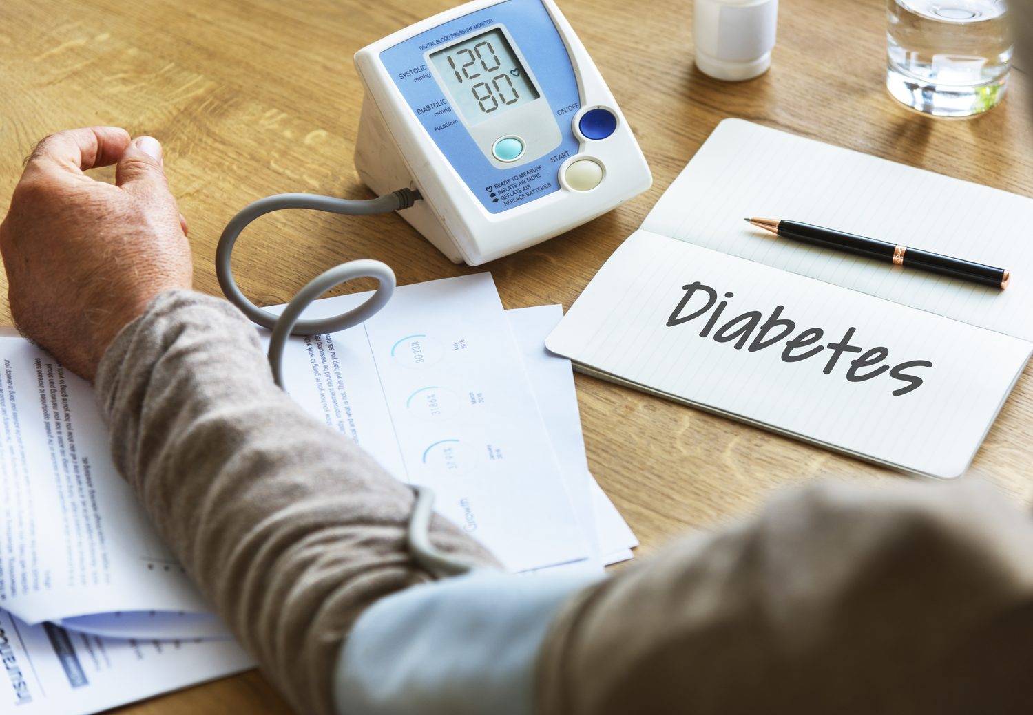 A blood pressure monitor and diabetes notes on a desk during a health check