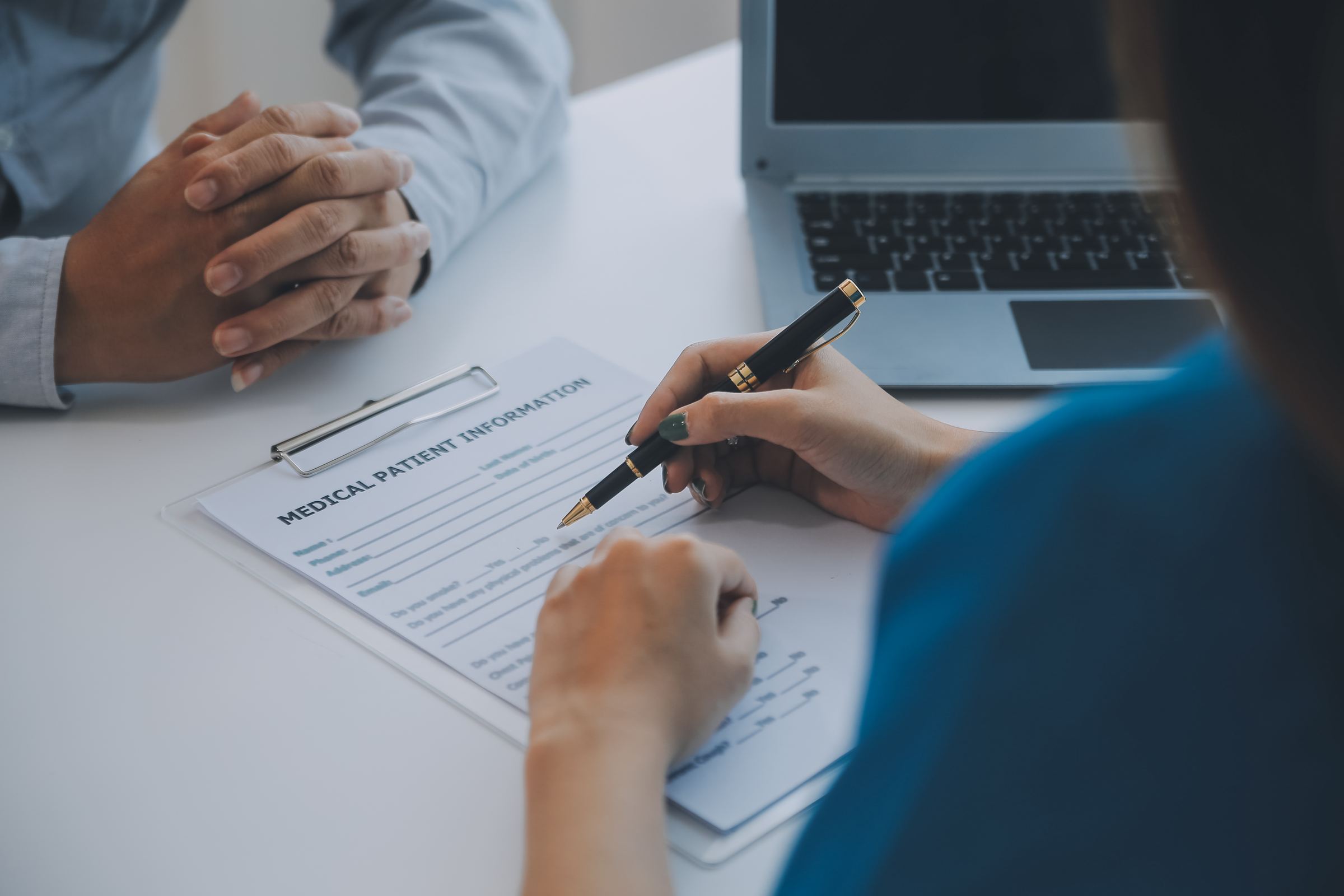 A medical form being filled in at a desk during an appointment